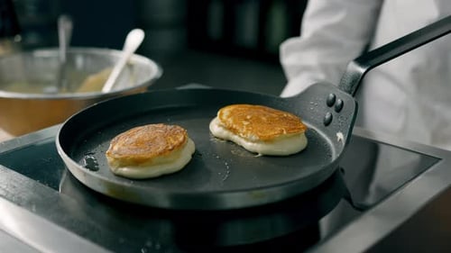 Pancakes with a crust are fried in a pan. Professional kitchen in the restaurant