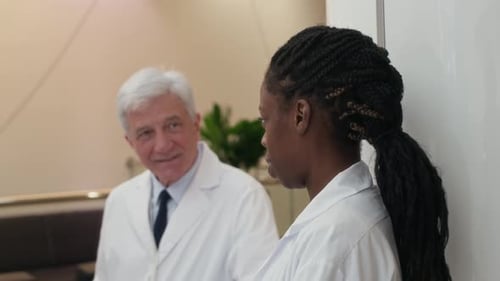 Diverse Group of Medical Staff Talking in Hospital Hallway
