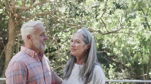 Middle aged portrait of caucasian couple in garden with copy space
