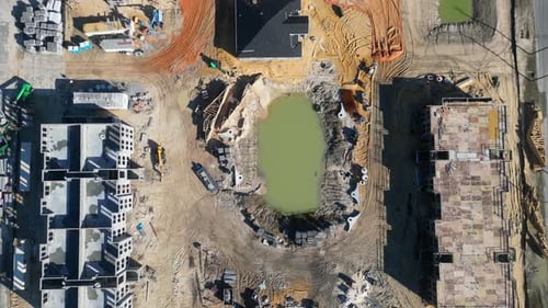 New apartments under construction viewed from above with heavy equipment in various stages