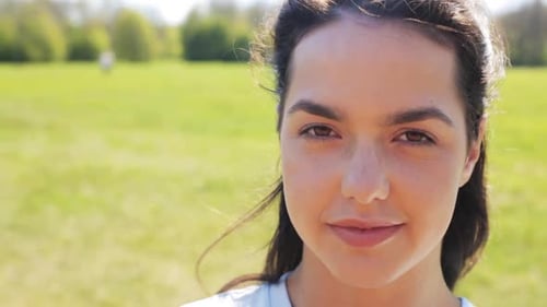 Happy young hispanic woman smiling naturally outdoors in a summer meadow