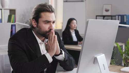 Employee Sitting at Office Desk with Computer Indoor