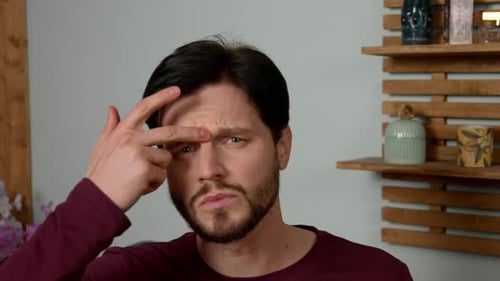 Man Makes Finger Gun Shape at Temple Indoors