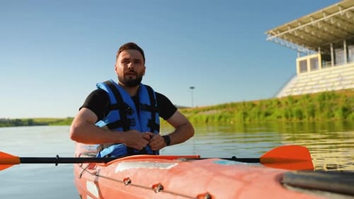 Man kayaking on river fastens life vest