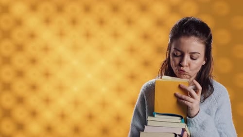 Woman Holding a Stack of Books and Smiling