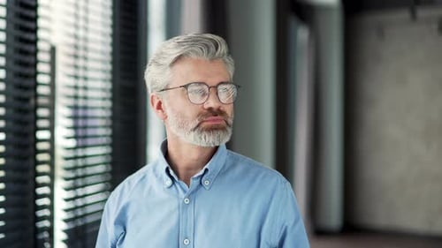 Mature Man with Gray Hair Standing with Arms Crossed