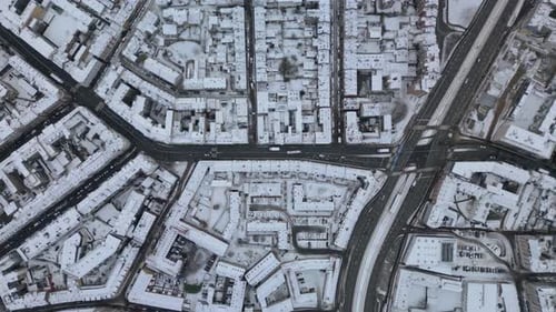 Top-Down View Of Snow-Covered City With Roads And Buildings