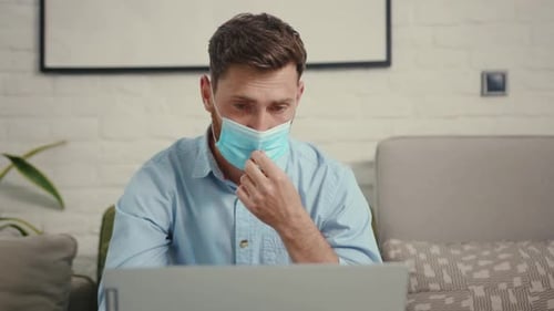 Man lowers protective face mask to speak