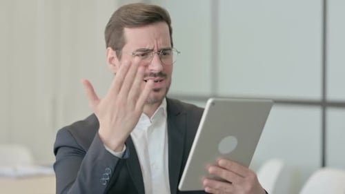 Frustrated Man Using Tablet in Office Environment