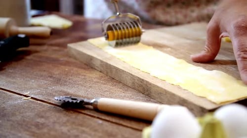 Cutting Fresh Pasta Dough on a Wooden Board