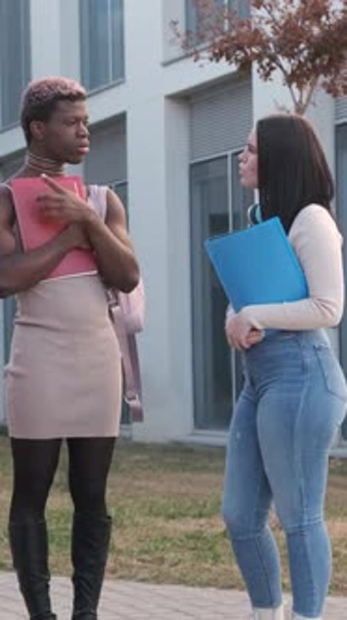 Couple of Friends Talking Distracted Outside a University Campus