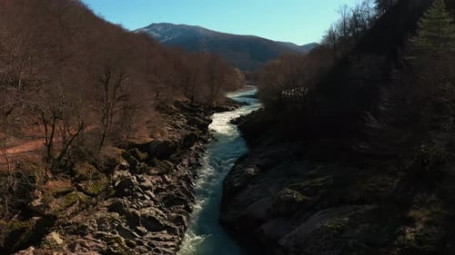 Gebirgsfluss mit felsigem Ufer im Herbst