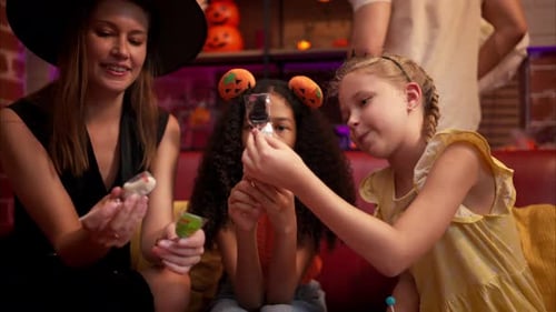 Woman and Children Enjoying Halloween Lollipops