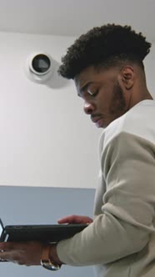 Young Adult Typing on Laptop Indoors