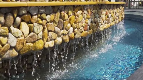 Stonewall Water Feature. Water cascading Down Into A Pool, REAL TIME
