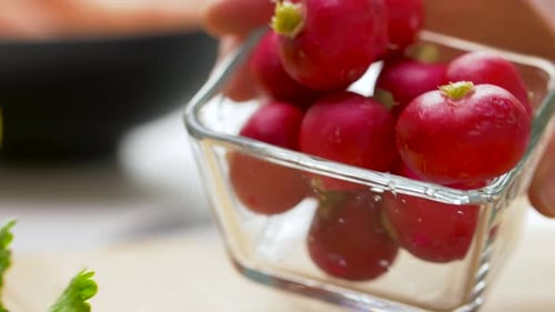 Radishes in Glass Bowl Being Poured on Board