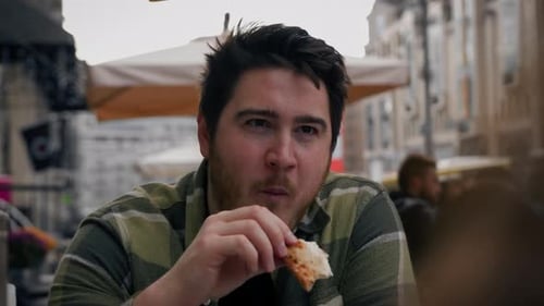A man on a date with a woman eats pizza and tells jokes