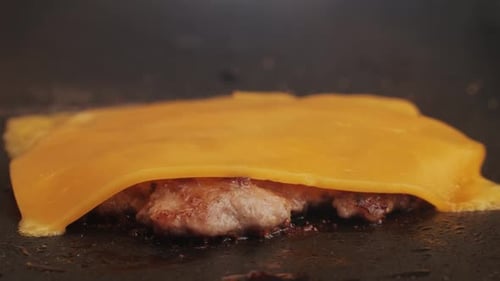 Cooking American Fat Smash Burger with Cheese Slice on Top on Grill Closeup Beef or Pork Cutlet