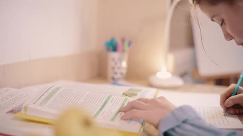 Child Completing Homework at Desk With Lamp