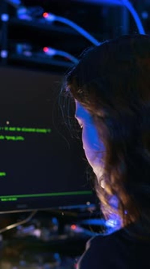 Mujer programando en una sala de servidores. Vertical