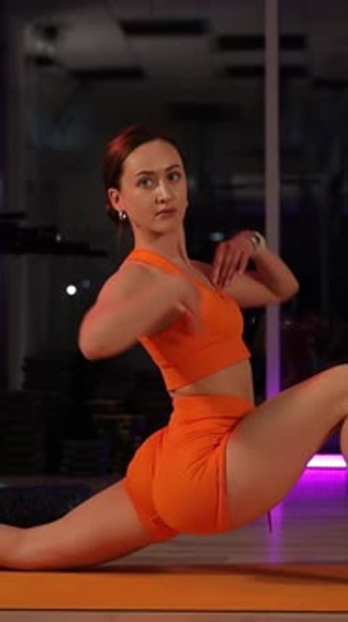 Athletic Girl Performing a Full Split in a Modern Gym Vertical Video