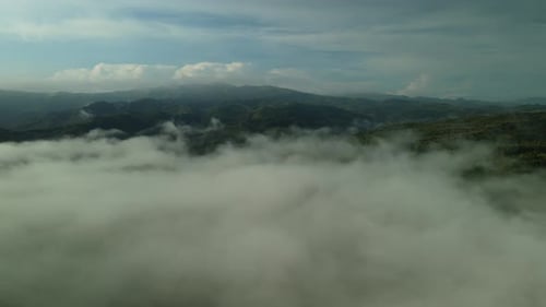 Lush Green Mountains Emerge from Cloudscape