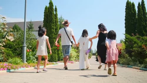 Happy Family Walking in Sunny Garden Setting