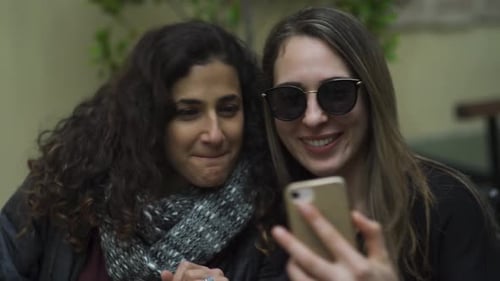 two young attractive women having fun, making silly duck faces and taking selfies on vacation. 4K