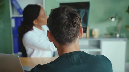 Doctor Explains X-ray to Patient in Office