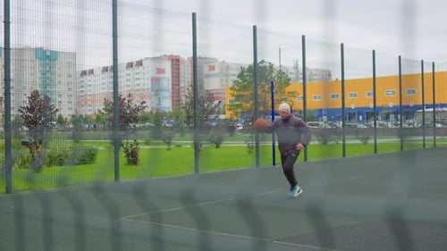 Man Dribbling and Shooting Basketball at Outdoor Court