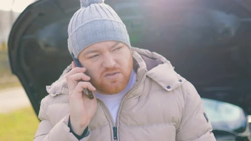 Man Using Phone With Car Trouble on Road