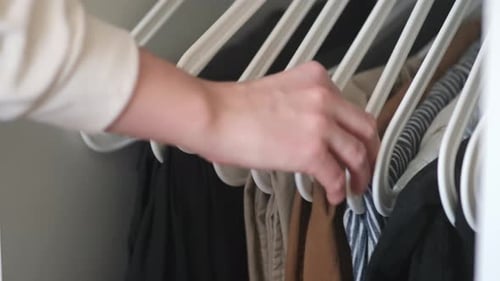 Close-up of woman's hands hanging a clothing on a hanger