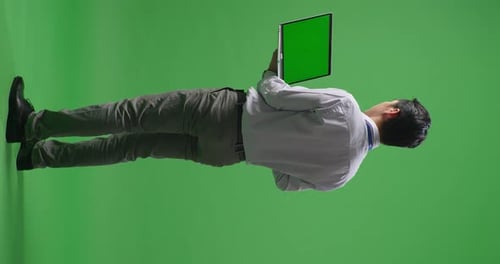 Back View Of Full Body Asian Business Man Using Laptop Computer An Looking Around On Green Screen