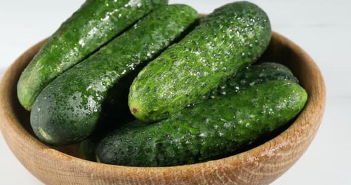 Close-up fresh green cucumbers in wooden bowl