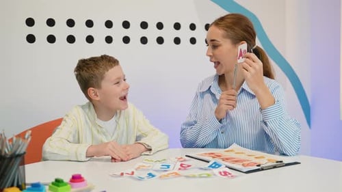 Speech Therapist Working with Young Boy Pronouncing Sounds