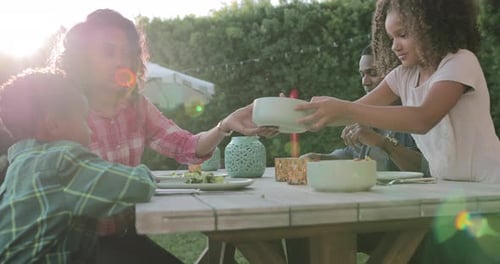 Family sharing a meal together in backyard