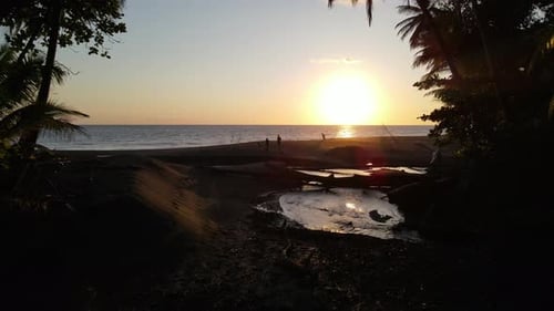 Traveling family watching the sunset in a deserted beach in Osa Peninsula, Costa Rica