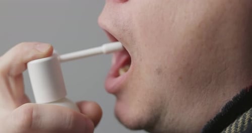 Adult Using Throat Spray Medicine Close Up