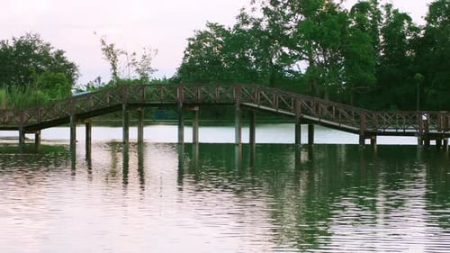 Wooden bridge walkway on the lake scenery natural attractions at sunset.