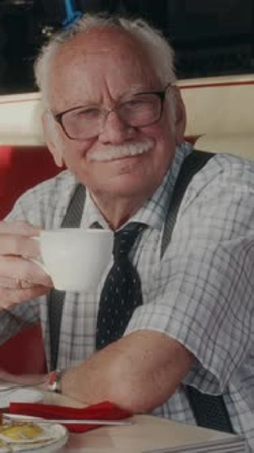 Senior Man Drinks Coffee at Restaurant