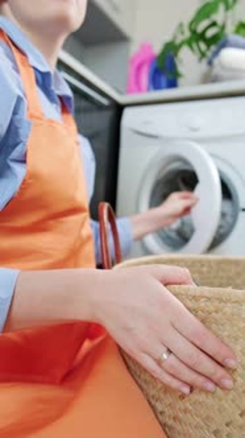 Woman checks clean laundry for wash quality after washing machine cycle, home laundry and routine ta