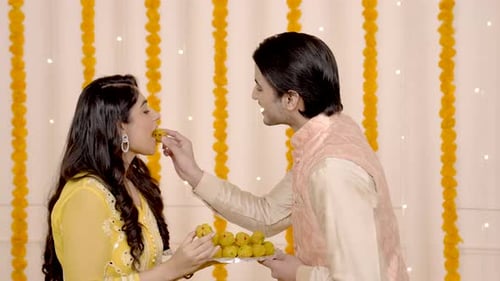 Cute Indian couple eating sweets on Diwali