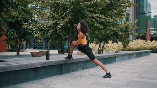 Attractive Woman Engaging in Stretching Exercises on Street