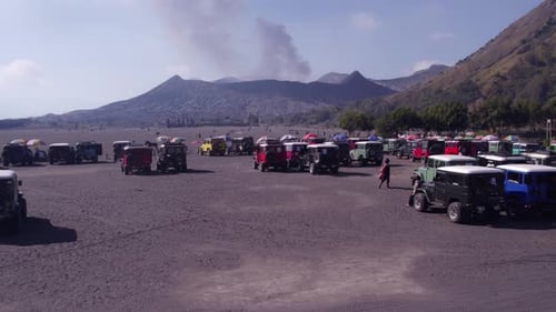 Luftaufnahme des rauchenden Vulkans, Jeeps, Sand, Bromo, Ost-Java, Indonesien.