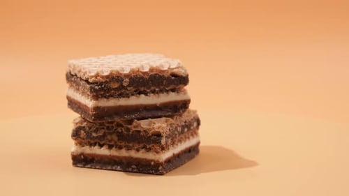 Delicious chocolate wafers with hazelnuts rotate on an orange background.