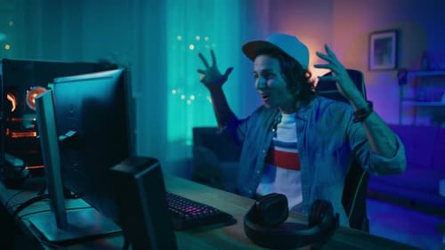 Portrait of a Handsome Surprised and Excited Young Man Watching an Action Video on a Computer. He i