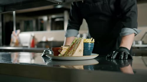 Professional kitchen in the restaurant of the hotel, the chef is standing with a club sandwich
