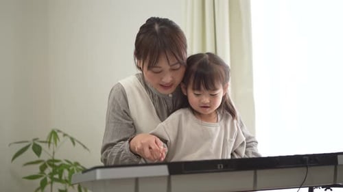 Adult and Child Play Keyboard Indoors Together