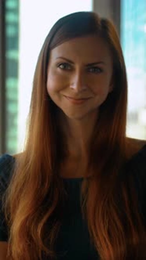 Vertical of Portrait of Young Successful Redhair Woman Entrepreneur Standing in Office Huge Windows