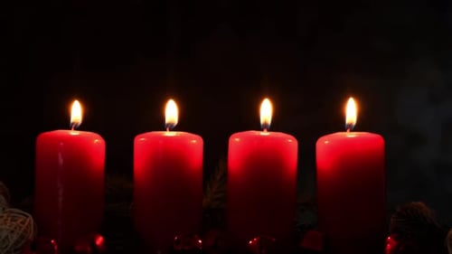 Vier rote Adventskerzen brennen auf dunklem Hintergrund, Tannenzweige und weihnachtliche Zero Waste-Dekorationen